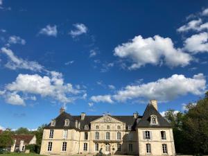 an old mansion with a blue sky and clouds at Château de Cesny-aux-Vignes in Cesny-aux-Vignes