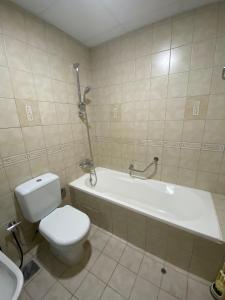 a bathroom with a toilet and a tub and a sink at Taji hostel for male in Dubai