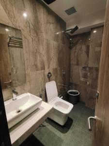 a bathroom with a white toilet and a sink at MIG SUITES in Mumbai +5 photos