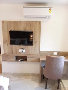 a room with a desk with a television and a chair at MIG SUITES in Mumbai