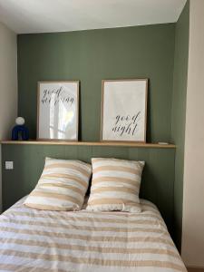 a bedroom with a bed with two pictures on the wall at Cozy Appartment Champollion 1 in Figeac