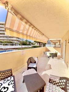 einen Balkon mit Tischen, Stühlen und einem Tisch in der Unterkunft Ventura Park B 4 in Salou