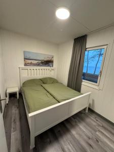 Un dormitorio con una cama blanca y una ventana. en Surf-Bungalow in erster Reihe, en Klein Strömkendorf