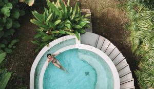 a man swimming in a pool with a bunch of bananas at Proud Phu Fah Maerim Resort in Mae Rim
