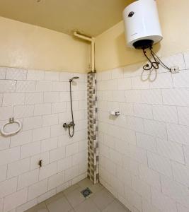 a bathroom with a white tiled shower with a light at Magnifique studio centre ville Saint louis in Saint-Louis +10 photos
