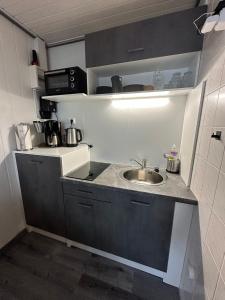 Una pequeña cocina con fregadero y encimera. en Surf-Bungalow in erster Reihe, en Klein Strömkendorf