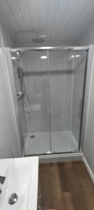 a shower with a glass door in a bathroom at Ben Lomond Cottage in Arrochar