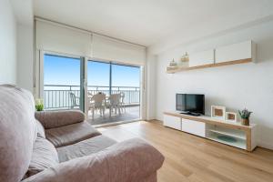 Una sala de estar con un sofá y un televisor. en BELL RACO Superior, en La Pineda