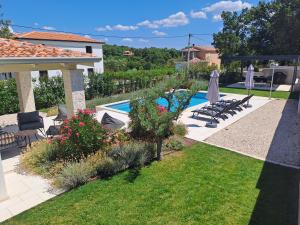 a backyard with a swimming pool and a house at Villa Meliora in Vižinada