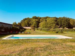 a swimming pool in the middle of a grass field at Château de Cesny-aux-Vignes in Cesny-aux-Vignes