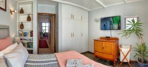 a bedroom with a bed and a dresser in it at Peaceful Perch in Walvis Bay