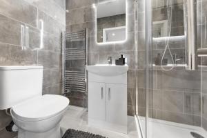 a bathroom with a toilet and a sink and a shower at Warm & Bright Studio, Easy Commute to Central in New Southgate +39 photos