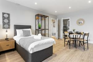 a bedroom with a bed and a table with chairs at Warm & Bright Studio, Easy Commute to Central in New Southgate