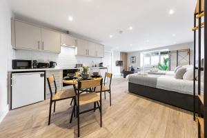 a kitchen and living room with a bed and a table at Warm & Bright Studio, Easy Commute to Central in New Southgate