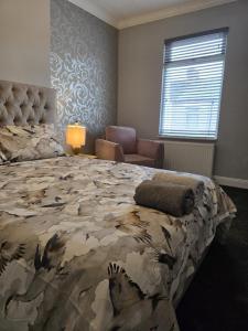 a bedroom with a large bed and a chair at Aldam House in Darlington