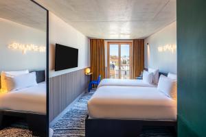 a hotel room with two beds and a window at TRIBE Paris Clichy in Clichy