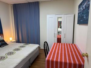 een kleine slaapkamer met een bed en een tafel bij Chadstone Holiday E4 Villa in Oakleigh South