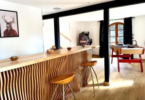 a bar in a room with a table and stools at chalet la forgerie Piscine Jacuzzi Cinéma in La Forge