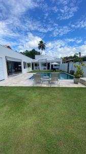 a house with a swimming pool and a yard at Casa Mar Sonho Verde in Paripueira