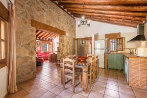 eine Küche und ein Esszimmer mit einer Steinmauer in der Unterkunft Casa Rural Cortijo Plantio Castril in Castril