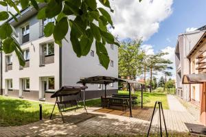 a patio with a table and benches in a yard at HomeKoko Apartments in Katowice