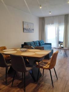 a living room with a table and a blue couch at Magic Sea View - Apartments Rina in Karlobag