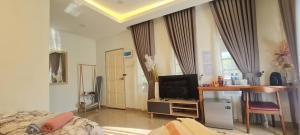 a bedroom with a bed and a desk with a television at CBHResort Agrofarm in Baling