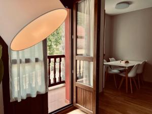 a door to a balcony with a table and a window at Apartamento Acogedor con Vistas Espectaculares en Liébana, Picos de Europa in Camaleño