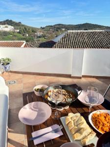 einen Tisch mit Essen und Weingläsern auf dem Balkon in der Unterkunft La Casita de San Benito in Cazalla de la Sierra