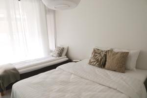 a bedroom with a white bed and a window at Henniina V Pakkahuone III - City Center in Oulu