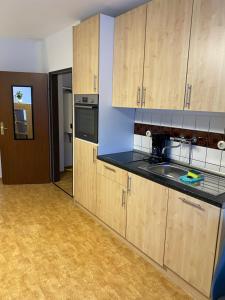 a kitchen with wooden cabinets and a black counter top at Apartment am Dom in Dinklage in Dinklage