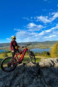 a person riding a bike on top of a rock at Pocztówka z Mizernej, drewniane domki, widok na Tatry, blisko Velo Czorsztyn, Jezioro Czorsztyńskie, rowery, spokojna okolica in Kluszkowce