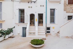 un edificio blanco con escalera y patio en Sea View Romantic Apartments Al Vecchio Porto, en Monopoli