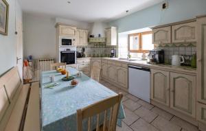 une cuisine avec une table et un plan de travail bleu dans l'établissement Amazing Home In Saint-Pé-De-Léren, à Saint-Pé-de-Léren