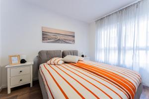 une chambre avec un lit avec une couverture rayée dans l'établissement Flex SelfCheckIns 98 - Zagreb - 2 Bedrooms - Parking - Loggia, à Velika Mlaka