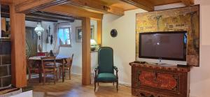 a living room with a television and a dining room at La Maison Jaune in Vendenheim