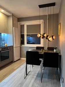 a kitchen and dining room with a table and chairs at LOCUSDO Apartment No.31 in Mažeikiai