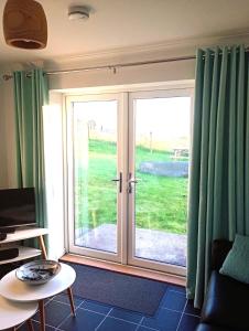 a living room with a sliding glass door at Crossroads Cottage in Sollas
