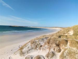 a sandy beach with the ocean in the background at Crossroads Cottage in Sollas