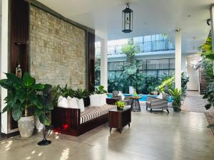 暹粒Maison Leab的一栋种有植物的建筑内，大厅里摆放着沙发