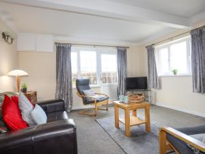 a living room with a couch and a table at Glan Y Don Bach in Abersoch