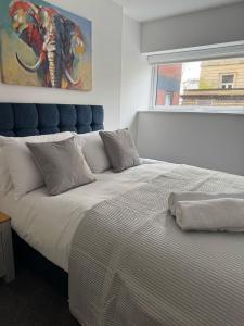 ハルにあるCosy Executive City Apartment 3の壁に絵が飾られた大きなベッドのある寝室