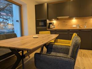a kitchen with a wooden table and chairs at Gartenapart in Pfunds