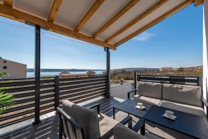 a patio with a table and chairs on a balcony at Villa Sea Pearl ZadarVillas in Maslenica
