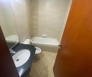 a bathroom with a sink and a toilet and a tub at ASDK Home 908-14 in Dubai +3 photos