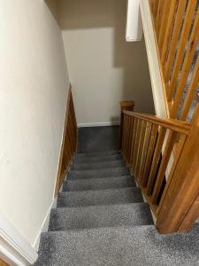 a stairway with a wooden railing and a stair case at Graceful Lodge in Leicester