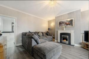 a living room with a couch and a fireplace at Comfortable Cottage in Greater Manchester in Glazebury