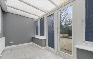 an empty room with a conservatory with windows at Comfortable Cottage in Greater Manchester in Glazebury