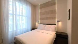 a bedroom with a white bed and a window at 39 Studios in London