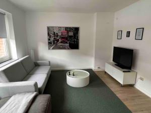 a living room with a couch and a tv at Wohnung mit Balkon am Rhein in Düsseldorf